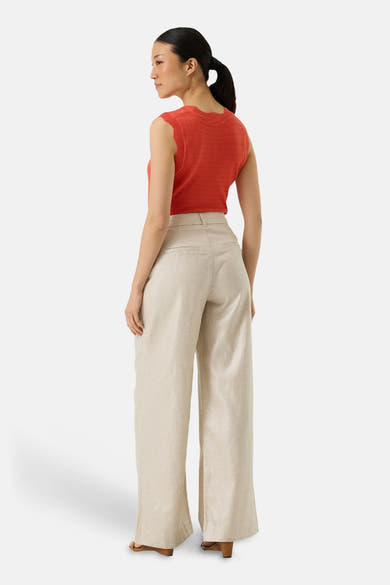 Top sans manches orange de GARCIA, texture tricotée et bords festonnés, porté avec un pantalon taille haute beige.
