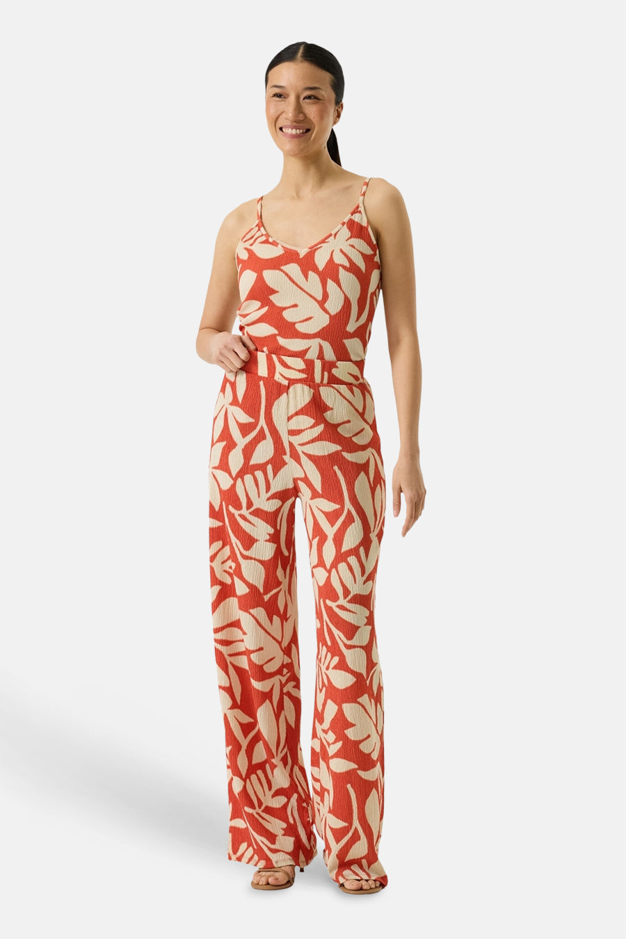 Débardeur orange à fines bretelles de GARCIA, imprimé feuilles, porté avec un pantalon assorti.