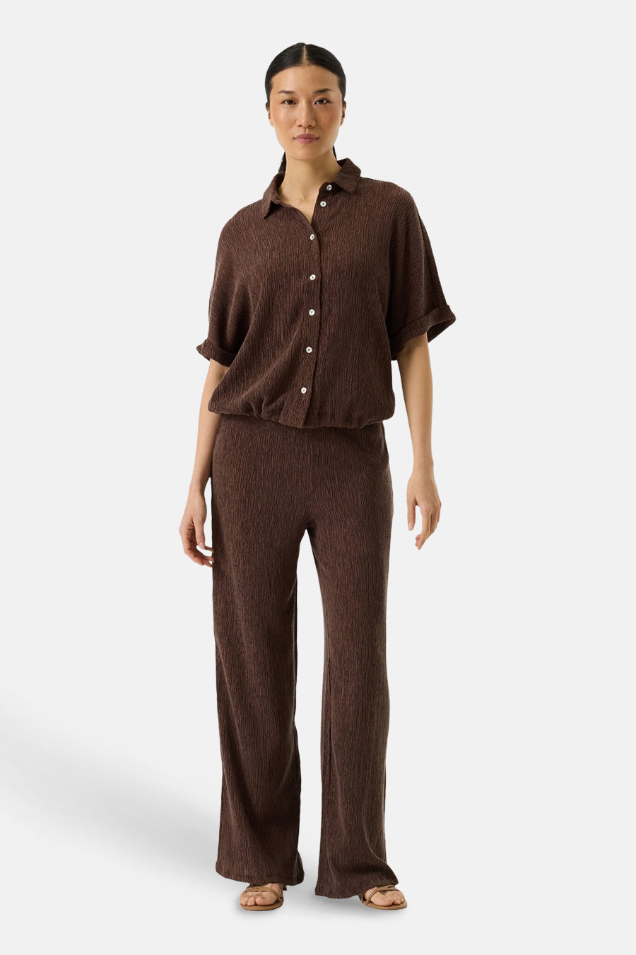 Chemise brun à manches courtes de GARCIA, en tissu texturé, portée avec un pantalon assorti.