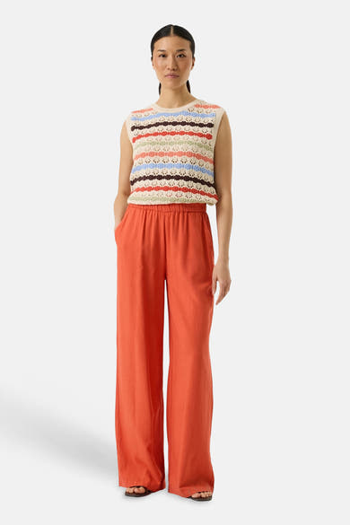 Pull multicolore col rond de GARCIA, à rayures horizontales et pantalon orange taille haute.
