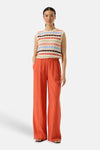 Pull multicolore col rond de GARCIA, à rayures horizontales et pantalon orange taille haute.
