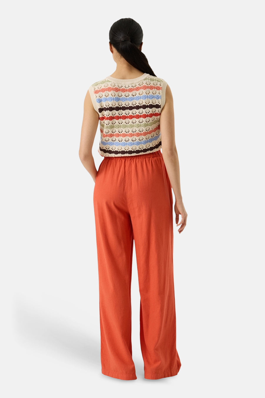 Pull multicolore de GARCIA, rayures horizontales, porté avec un pantalon orange taille haute, vue de dos.
