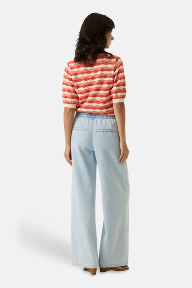 Pull multicolore GARCIA, à motif géométrique losanges, porté avec un pantalon large bleu clair à taille élastique.
