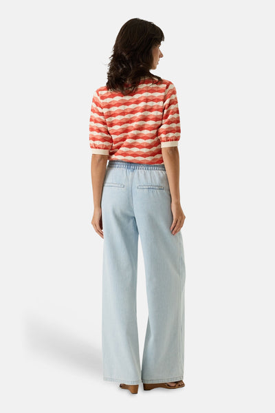 Pull multicolore GARCIA, à motif géométrique losanges, porté avec un pantalon large bleu clair à taille élastique.
