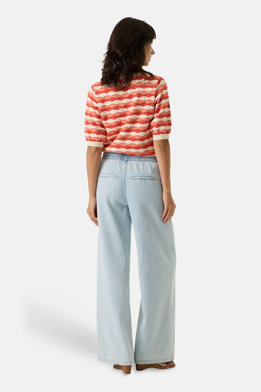 Pull multicolore GARCIA, à motif géométrique losanges, porté avec un pantalon large bleu clair à taille élastique.
