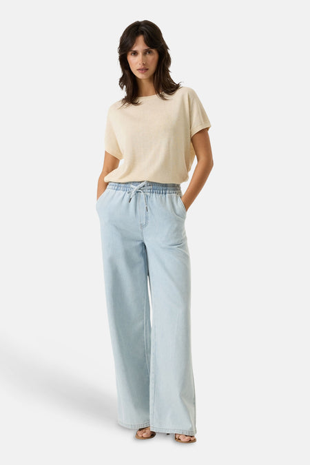 Pull beige à col rond de GARCIA, porté avec un pantalon ample bleu clair.