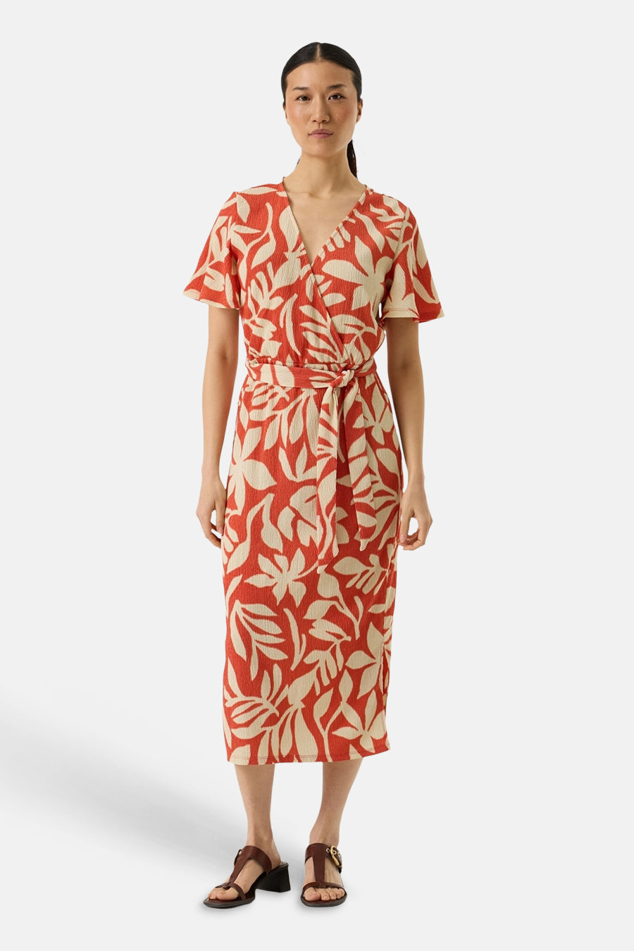 Robe multicolore GARCIA, avec motif floral beige et nouée à la taille, portée avec des sandales marron.