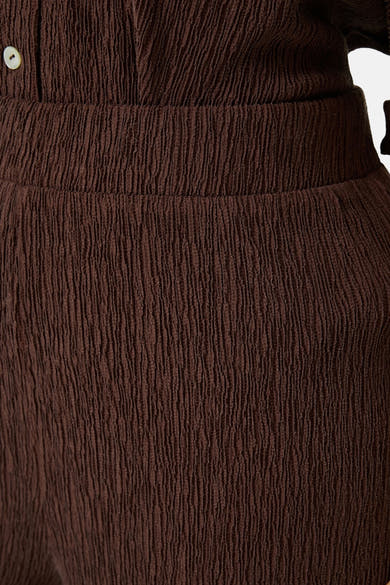 Bruine textuur broek van GARCIA, met elastische tailleband en geplooide details.