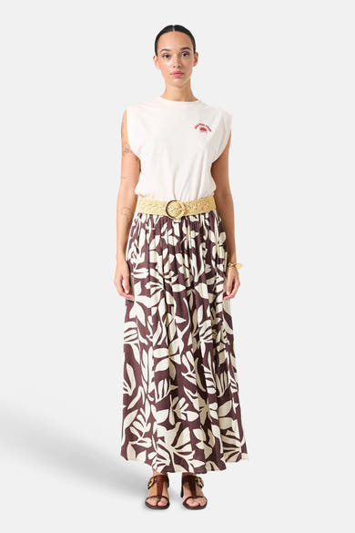 Jupe longue multicolore de GARCIA, à motif floral marron et beige, avec une ceinture tressée et des sandales marron.
