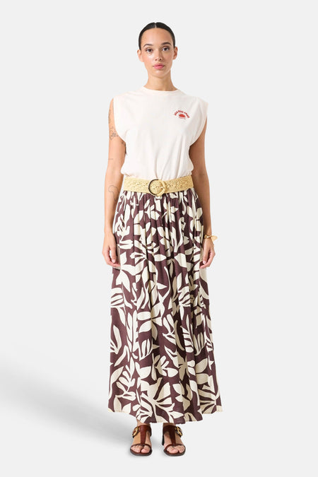 Jupe longue multicolore de GARCIA, à motif floral marron et beige, avec une ceinture tressée et des sandales marron.

