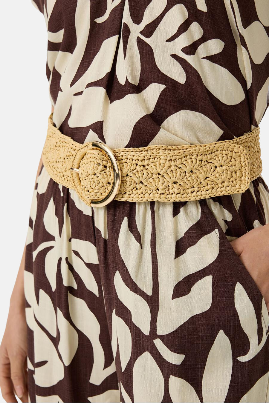 Beige stroken riem van GARCIA, met een gouden ronde gesp op een jurk met bladerpatroon.