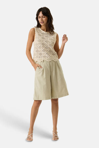 Bermuda beige de GARCIA, coupe ample, porté avec un haut en crochet et des sandales à talons.