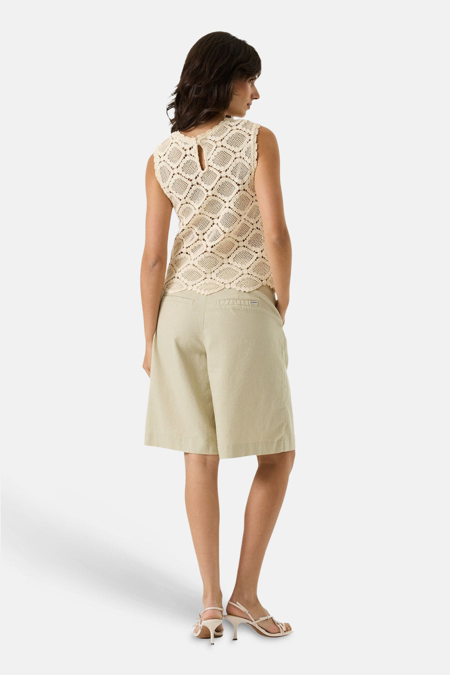 Bermuda beige de GARCIA, coupe large, avec poches latérales et ourlet au-dessus du genou, porté avec des sandales à talons.
