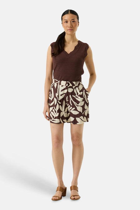 Short multicolore de GARCIA, avec un motif de feuilles beige et porté avec un haut marron et des sandales marron clair.
