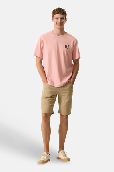 T-shirt rose à manches courtes de GARCIA avec un logo noir sur la poitrine, porté par un homme en short kaki et baskets claires.