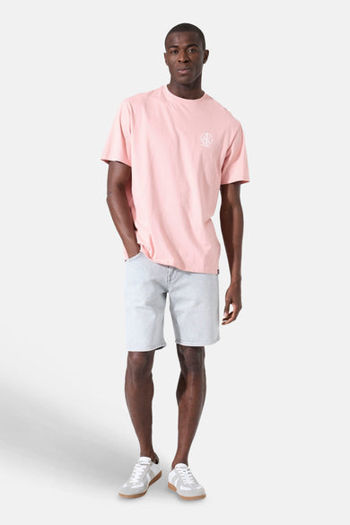Roze T-shirt van GARCIA met een wit logo op de borst, gedragen door een man in een spijkerbroek en sneakers.