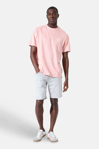 Roze T-shirt van GARCIA met een wit logo op de borst, gedragen door een man in een spijkerbroek en sneakers.