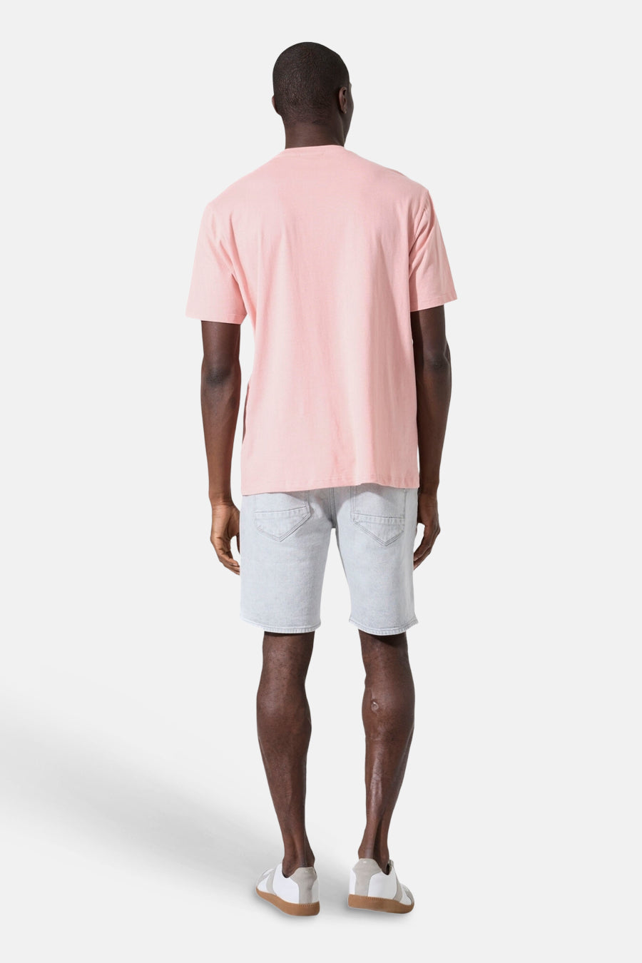 T-shirt rose de GARCIA, vue de dos sur un homme portant un short en jean clair et des baskets.