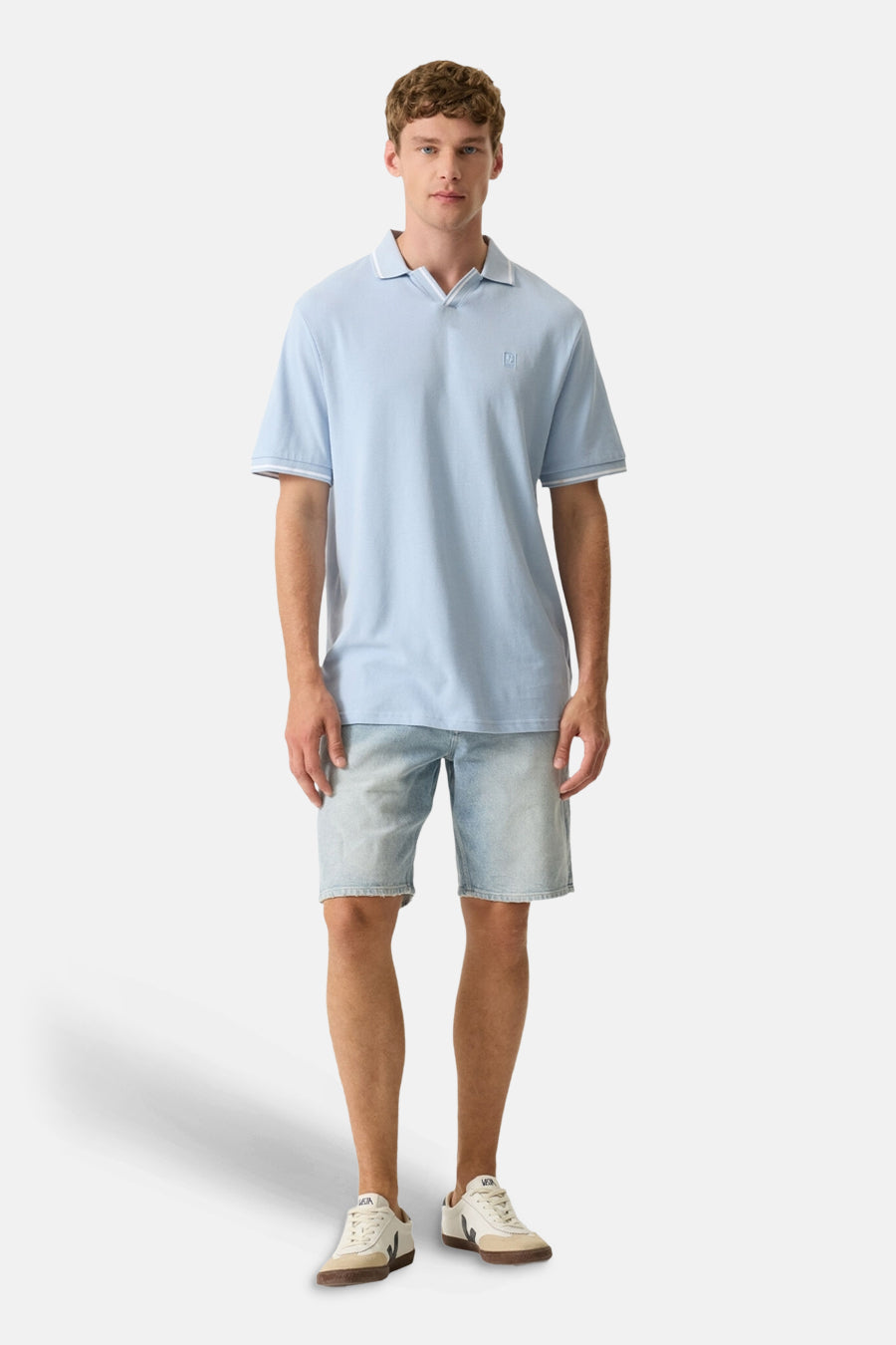 Polo bleu clair de GARCIA à col en V, avec liserés blancs et petit logo, porté par un homme.