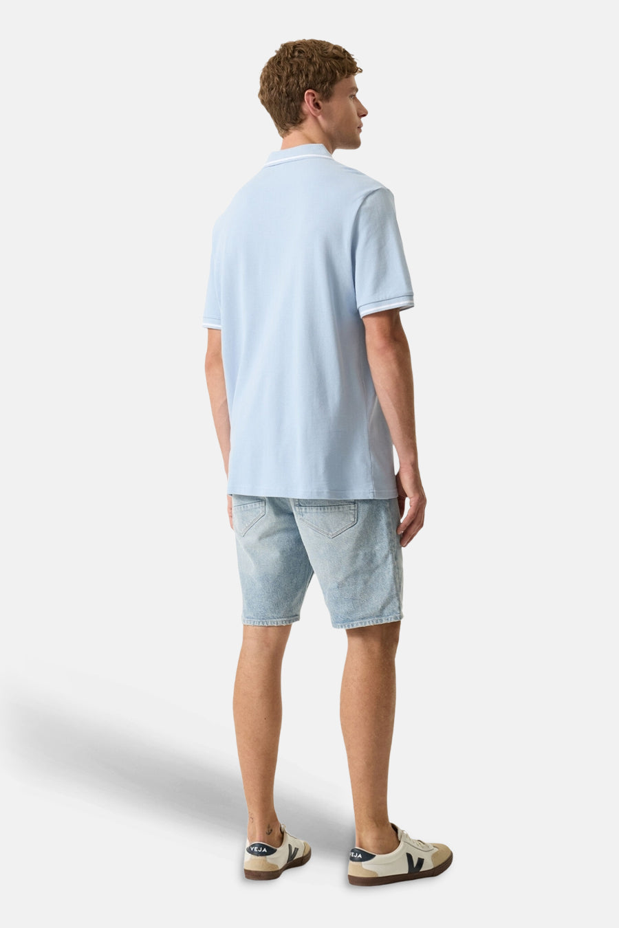 Polo bleu clair de GARCIA avec liserés blancs au col et aux manches, porté par un homme de dos.