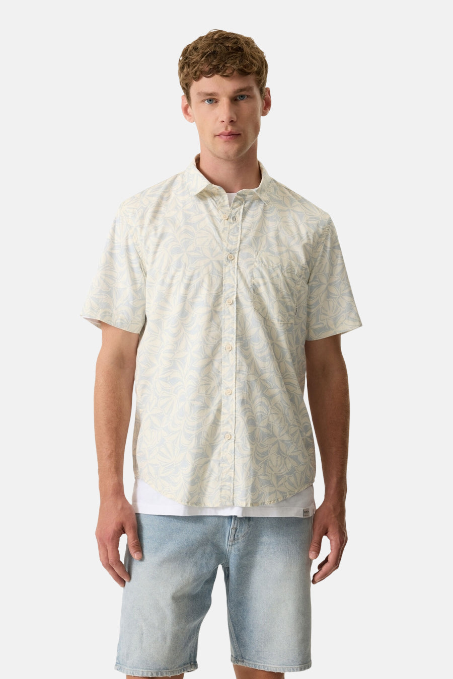 Chemise à manches courtes multicolore de GARCIA, avec motif végétal abstrait, portée sur un t-shirt blanc avec un short en jean clair.