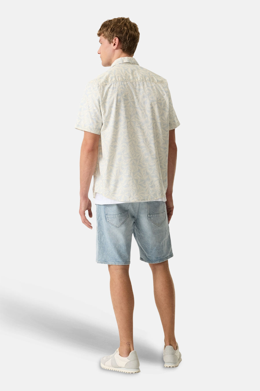 Chemise à manches courtes multicolore de GARCIA à motifs géométriques pâles, portée de dos avec un short en jean.