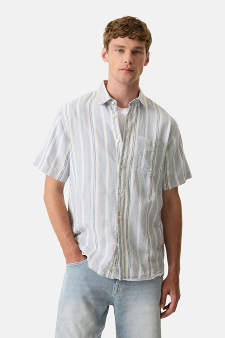 Chemise rayée bleue à manches courtes de GARCIA, portée sur un t-shirt blanc et un jean clair.