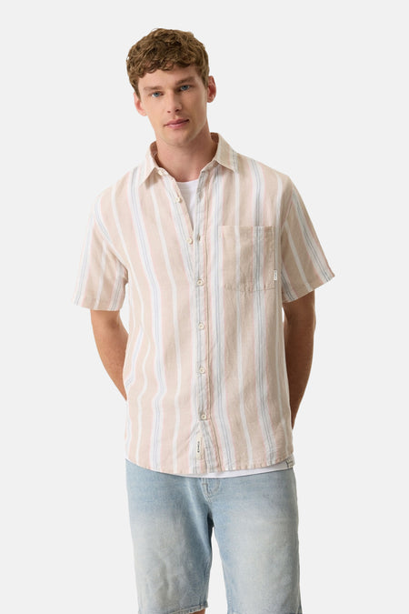 Chemise multicolore à manches courtes de GARCIA, à rayures verticales pêche, blanches et bleu pâle, portée sur un t-shirt blanc et un short en jean clair.