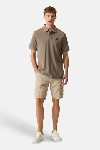 Short beige de GARCIA de style cargo avec poches latérales, porté par un homme avec un polo et des baskets.