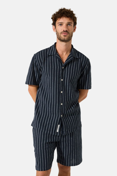 Short bleu de GARCIA à fines rayures verticales blanches, assorti à une chemise.