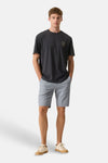 Short bleu de GARCIA avec micro-motif, porté par un homme avec un t-shirt gris foncé et des baskets beiges.
