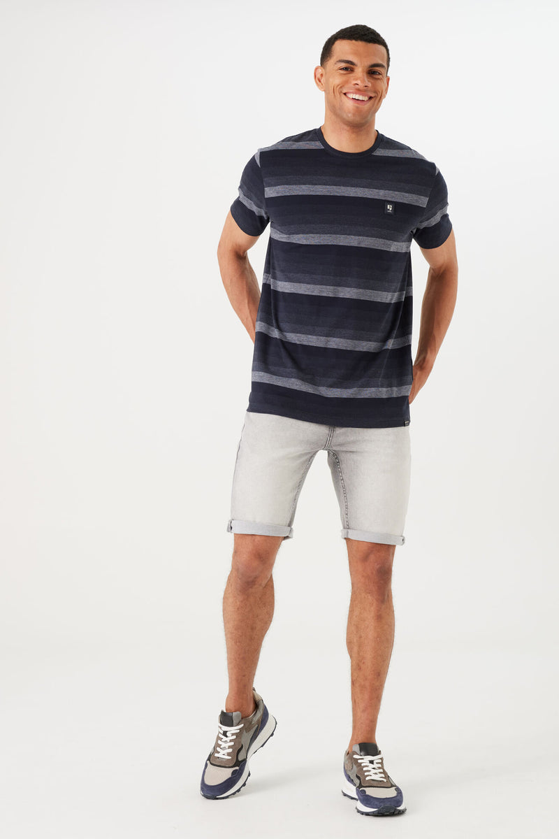 T-shirt à manches courtes bleu à rayures, de GARCIA, porté avec un short en jean et des baskets.