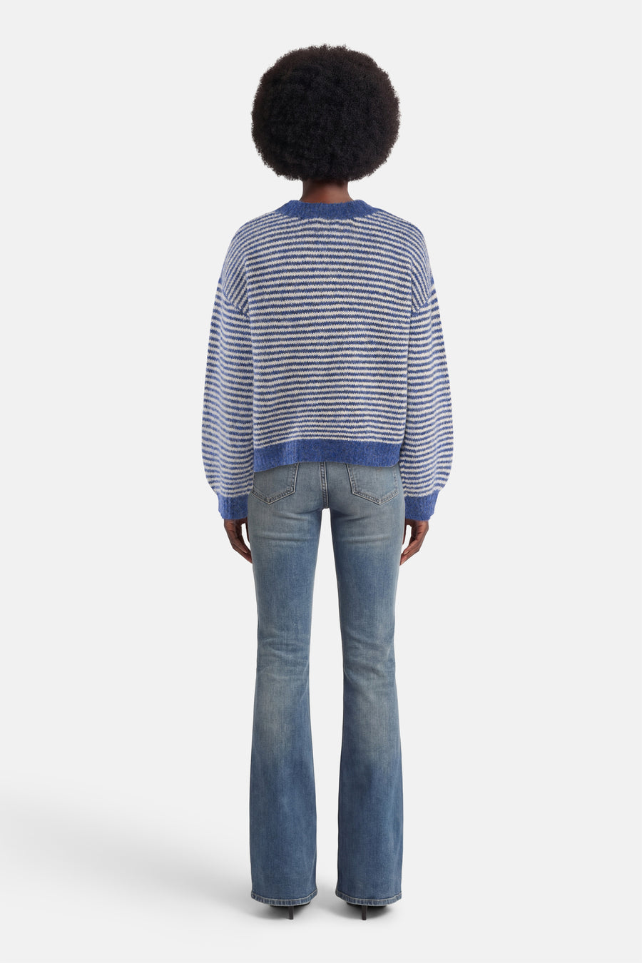 Pull à col rond bleu rayé de ADORE, porté avec un jean évasé, vue de dos.

