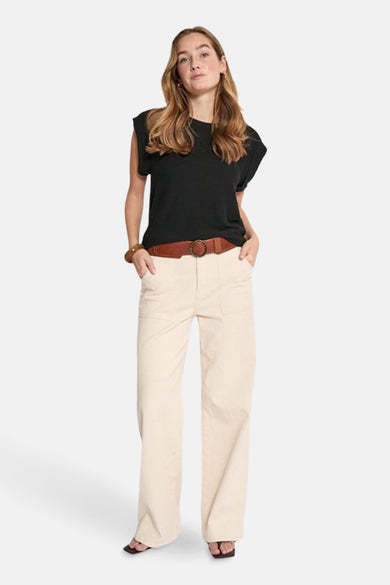 T-shirt noir à manches courtes de PEPPERCORN, porté avec un pantalon taille haute couleur crème et une ceinture marron.