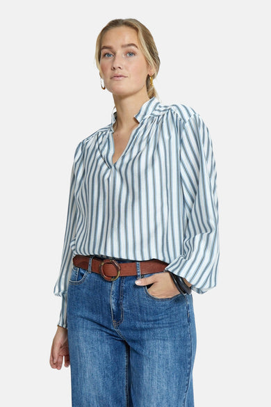 Blouse rayée bleu et blanc à manches longues de PEPPERCORN, portée avec un jean et une ceinture marron.