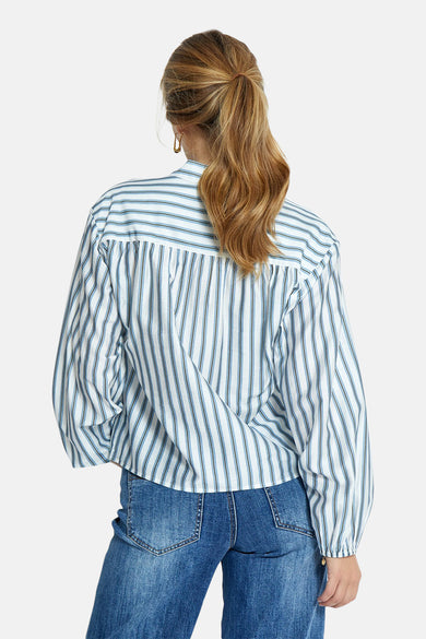 Blouse à manches longues bleue rayée de PEPPERCORN, vue de dos avec jean bleu.
