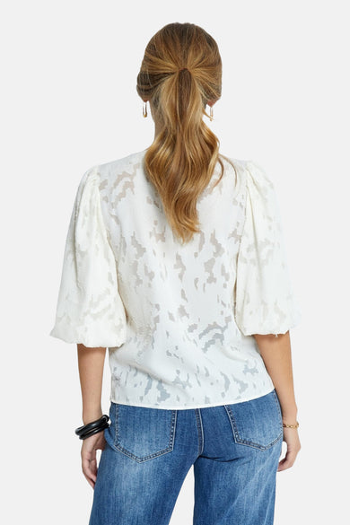 Beige 3/4 blouse van PEPPERCORN, met textuurpatroon, gedragen met een blauwe jeans en zwarte en gouden accessoires.
