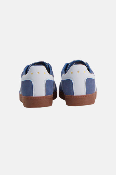 Baskets bleues de PANTOFOLA D'OR avec trois étoiles dorées sur le contrefort en cuir blanc et semelles marron.
