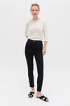 Zwarte broek van CAROLL, skinny fit, gedragen met een gestreept T-shirt en zwarte sandalen.