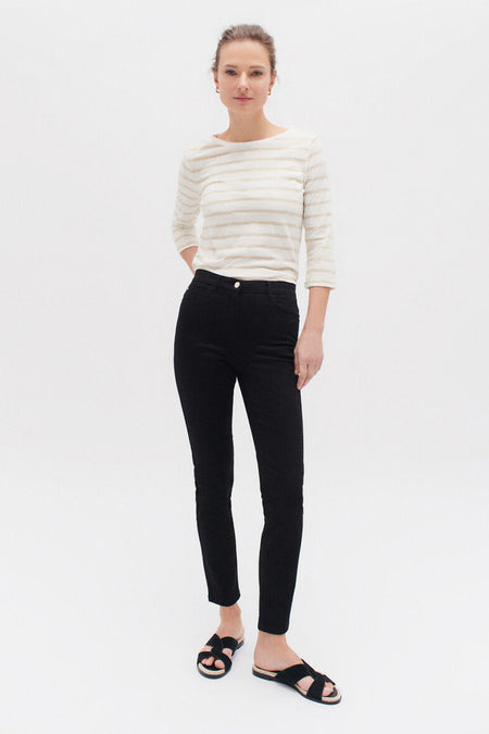 Zwarte broek van CAROLL, skinny fit, gedragen met een gestreept T-shirt en zwarte sandalen.