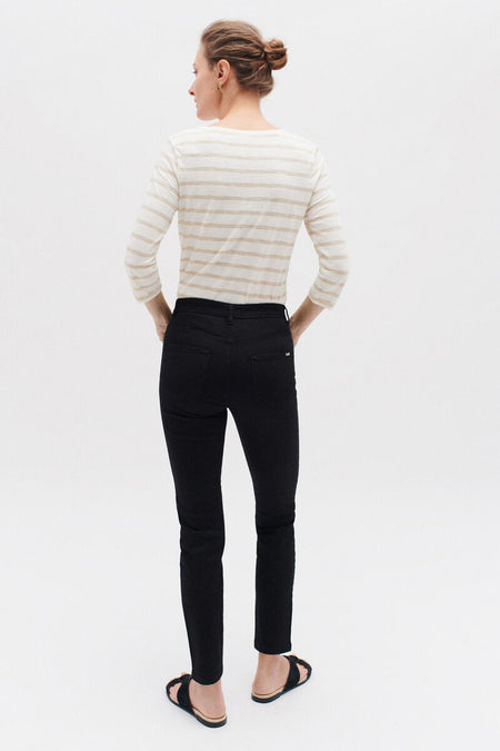Zwarte CAROLL broek, slim fit, gedragen met een gestreept T-shirt en platte sandalen.