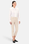 Chino 7/8 beige de CAROLL, porté avec une chemise blanche et des mocassins noirs.