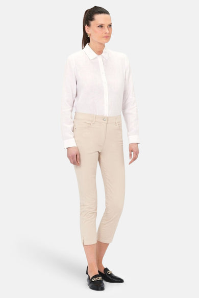 Chino 7/8 beige de CAROLL, porté avec une chemise blanche et des mocassins noirs.