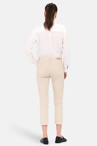 Chino 7/8 beige de Caroll, porté avec une chemise blanche et des mocassins noirs, vue de dos.

