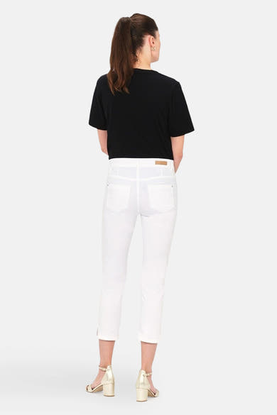 Chino 7/8 blanc de CAROLL, porté avec un t-shirt noir et des sandales dorées, vue de dos.
