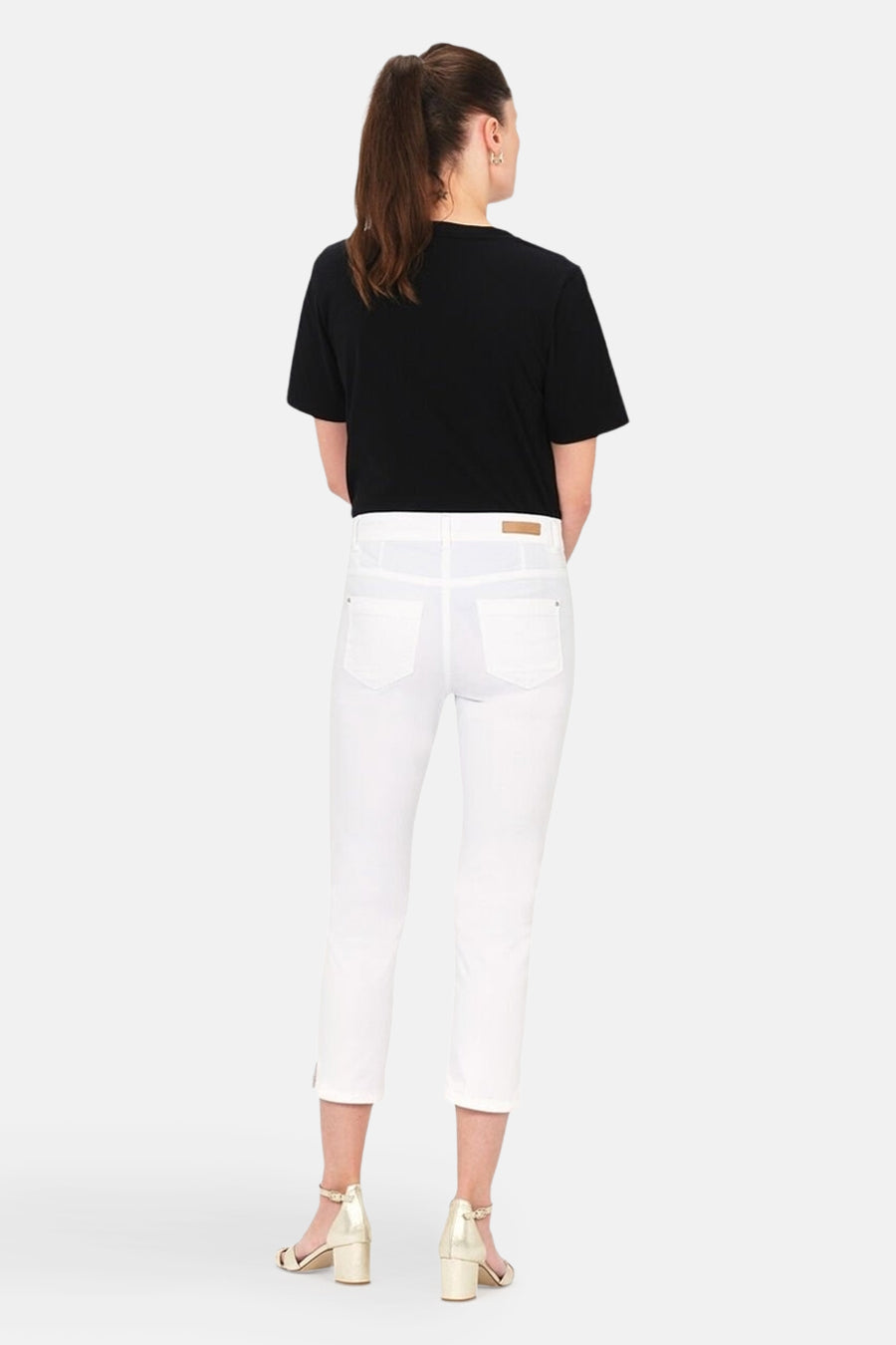 Chino 7/8 blanc de CAROLL, porté avec un t-shirt noir et des sandales dorées, vue de dos.
