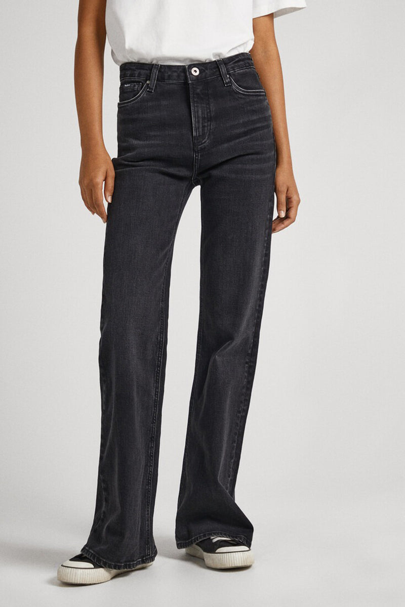 Dark blue flared jeans with slim fit through thigh, wide leg opening, worn with white top and black sneakers, front view