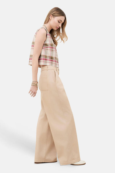 Chino beige taille haute de CAROLL à coupe large, porté avec un haut court à carreaux et des mocassins blancs.