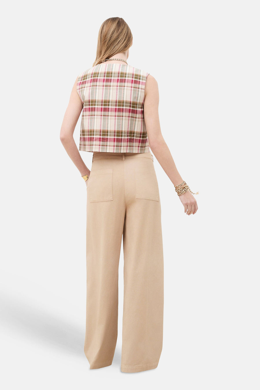 Chino beige de CAROLL, à jambes larges et poches arrière plaquées, porté de dos avec un haut écossais.