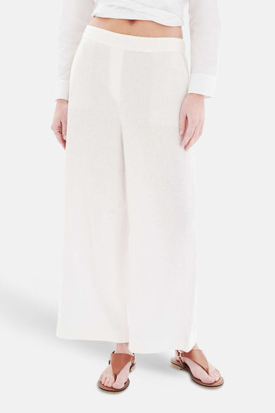 Witte broek met zakken van CAROLL, wijde pasvorm met bruine sandalen.